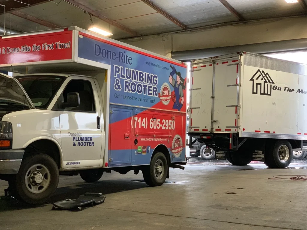 A truck parked in a garage next to another truck.