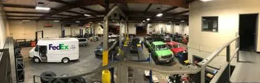 A large garage with many cars parked on the floor.