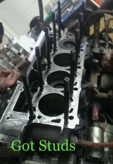 A close up of the engine block with some people working on it