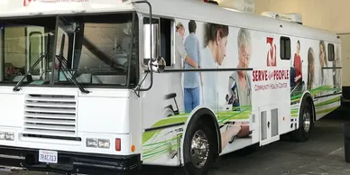 A white bus with a picture of people on it.